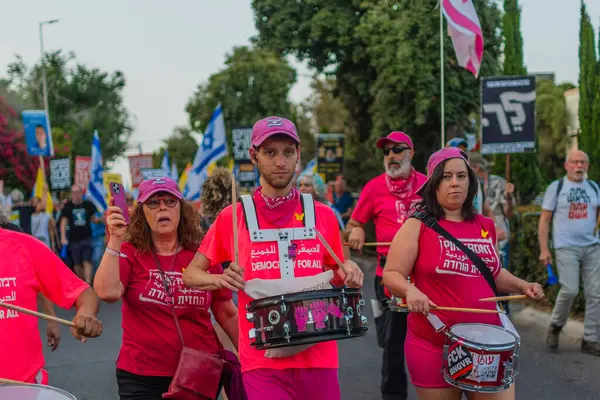 Hayfa, İsrail - 17 Mayıs 2025: İnsanlar savaşın sona ermesi, rehine anlaşmasının tamamlanması ve yeni seçimler çağrısında bulunan bir protesto yürüyüşüne (Pembe Cephe Grubu) katılıyor. Hayfa, İsrail
