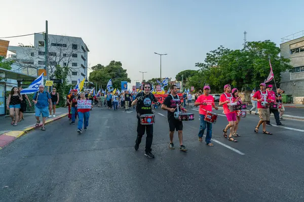 Hayfa, İsrail - 17 Mayıs 2025: Çeşitli tabelaları ve bayrakları olan insanlar, savaşın sona ermesi, rehine anlaşmasının tamamlanması ve yeni seçimlerin başlatılması için düzenlenen protesto mitingine katıldılar. Hayfa, İsrail