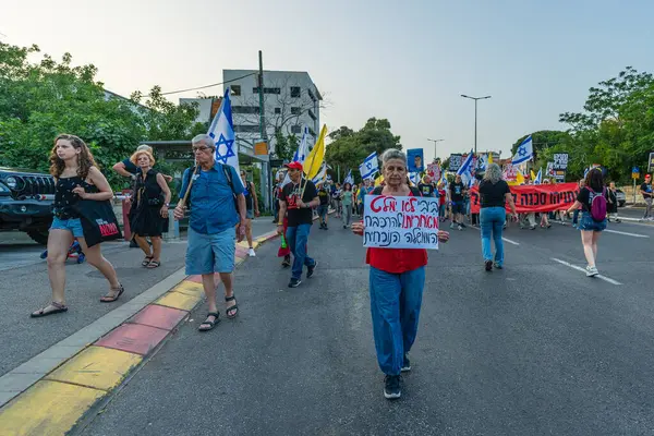 Hayfa, İsrail - 17 Mayıs 2025: Çeşitli tabelaları ve bayrakları olan insanlar, savaşın sona ermesi, rehine anlaşmasının tamamlanması ve yeni seçimlerin başlatılması için düzenlenen protesto mitingine katıldılar. Hayfa, İsrail