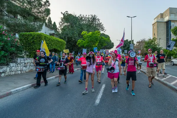 Hayfa, İsrail - 17 Mayıs 2025: İnsanlar savaşın sona ermesi, rehine anlaşmasının tamamlanması ve yeni seçimler çağrısında bulunan bir protesto yürüyüşüne (Pembe Cephe Grubu) katılıyor. Hayfa, İsrail