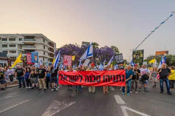 Hayfa, İsrail - 17 Mayıs 2025: Çeşitli tabelaları ve bayrakları olan insanlar, savaşın sona ermesi, rehine anlaşmasının tamamlanması ve yeni seçimlerin başlatılması için düzenlenen protesto mitingine katıldılar. Hayfa, İsrail