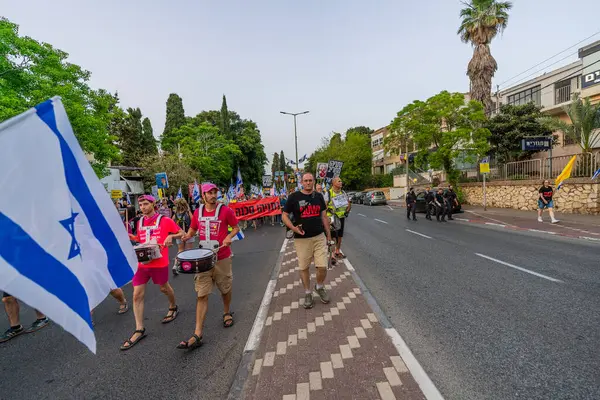 Hayfa, İsrail - 17 Mayıs 2025: Çeşitli tabelaları ve bayrakları olan insanlar, savaşın sona ermesi, rehine anlaşmasının tamamlanması ve yeni seçimlerin başlatılması için düzenlenen protesto mitingine katıldılar. Hayfa, İsrail