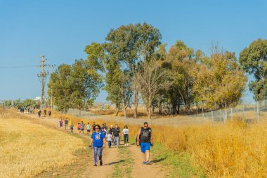 Kiryat Bialik, İsrail - 24 Mayıs 2025: İnsanlar En Afek Doğa Rezervi içinde ve çevresinde düzenlenen yıllık şehir yürüyüşüne katılarak, Kuzey İsrail 'deki Rehine Matan Angrest' e özgürlük çağrısında bulundu