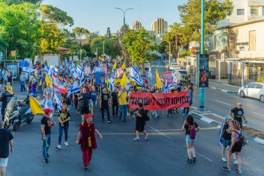 Hayfa, İsrail - 24 Mayıs 2025: Çeşitli tabelaları ve bayrakları olan insanlar, savaşın sona ermesi, rehine anlaşmasının tamamlanması ve yeni seçimlerin başlatılması için düzenlenen protesto mitingine katıldılar. Hayfa, İsrail