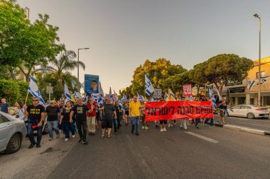 Hayfa, İsrail - 24 Mayıs 2025: Çeşitli tabelaları ve bayrakları olan insanlar, savaşın sona ermesi, rehine anlaşmasının tamamlanması ve yeni seçimlerin başlatılması için düzenlenen protesto mitingine katıldılar. Hayfa, İsrail