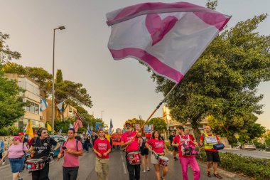 Hayfa, İsrail - 24 Mayıs 2025: İnsanlar savaşın sona ermesi, rehine anlaşmasının tamamlanması ve yeni seçimler çağrısında bulunan bir protesto yürüyüşüne (Pembe Cephe Grubu) katılıyor. Hayfa, İsrail
