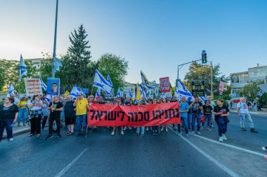 Hayfa, İsrail - 24 Mayıs 2025: Çeşitli tabelaları ve bayrakları olan insanlar, savaşın sona ermesi, rehine anlaşmasının tamamlanması ve yeni seçimlerin başlatılması için düzenlenen protesto mitingine katıldılar. Hayfa, İsrail