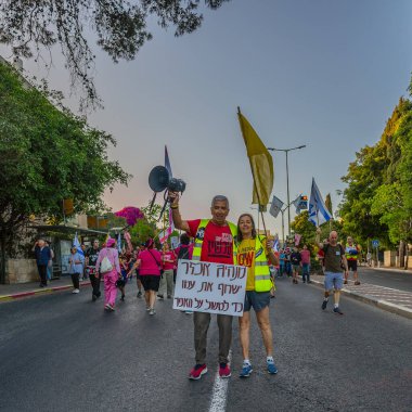 Hayfa, İsrail - 24 Mayıs 2025: Çeşitli tabelaları ve bayrakları olan insanlar, savaşın sona ermesi, rehine anlaşmasının tamamlanması ve yeni seçimlerin başlatılması için düzenlenen protesto mitingine katıldılar. Hayfa, İsrail