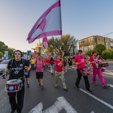 Hayfa, İsrail - 24 Mayıs 2025: İnsanlar savaşın sona ermesi, rehine anlaşmasının tamamlanması ve yeni seçimler çağrısında bulunan bir protesto yürüyüşüne (Pembe Cephe Grubu) katılıyor. Hayfa, İsrail