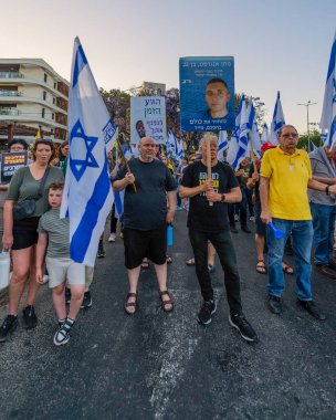 Hayfa, İsrail - 24 Mayıs 2025: Çeşitli tabelaları ve bayrakları olan insanlar, savaşın sona ermesi, rehine anlaşmasının tamamlanması ve yeni seçimlerin başlatılması için düzenlenen protesto mitingine katıldılar. Hayfa, İsrail