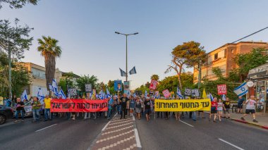 Hayfa, İsrail - 24 Mayıs 2025: Çeşitli tabelaları ve bayrakları olan insanlar, savaşın sona ermesi, rehine anlaşmasının tamamlanması ve yeni seçimlerin başlatılması için düzenlenen protesto mitingine katıldılar. Hayfa, İsrail