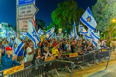 Hayfa, İsrail - 24 Mayıs 2025: Çeşitli tabela ve bayraklara sahip bir grup insan, savaşın sona ermesi, rehine anlaşmasının tamamlanması ve yeni seçimler için düzenlenen protesto mitingine katıldı. Hayfa, İsrail