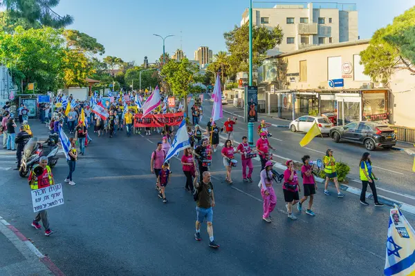 Hayfa, İsrail - 24 Mayıs 2025: Çeşitli tabelaları ve bayrakları olan insanlar, savaşın sona ermesi, rehine anlaşmasının tamamlanması ve yeni seçimlerin başlatılması için düzenlenen protesto mitingine katıldılar. Hayfa, İsrail
