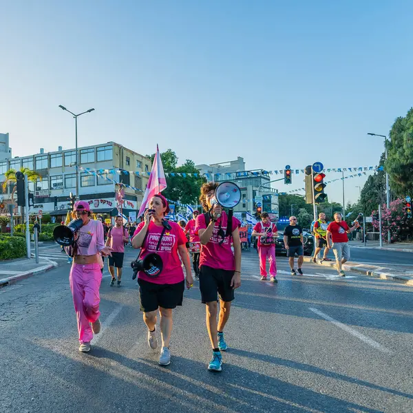 Hayfa, İsrail - 24 Mayıs 2025: İnsanlar savaşın sona ermesi, rehine anlaşmasının tamamlanması ve yeni seçimler çağrısında bulunan bir protesto yürüyüşüne (Pembe Cephe Grubu) katılıyor. Hayfa, İsrail