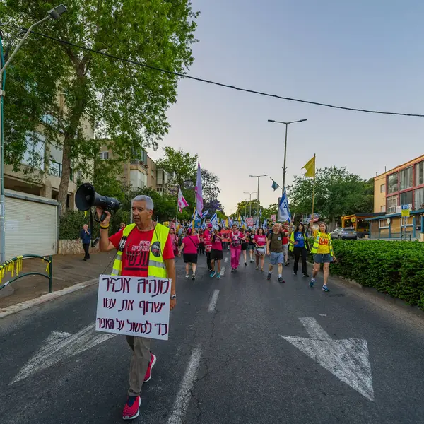 Hayfa, İsrail - 24 Mayıs 2025: Çeşitli tabelaları ve bayrakları olan insanlar, savaşın sona ermesi, rehine anlaşmasının tamamlanması ve yeni seçimlerin başlatılması için düzenlenen protesto mitingine katıldılar. Hayfa, İsrail