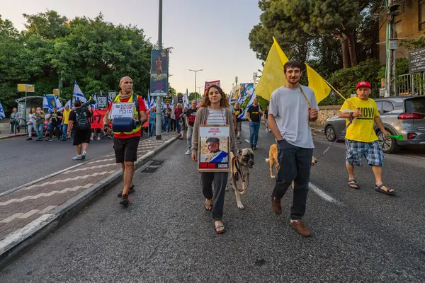 Hayfa, İsrail - 24 Mayıs 2025: Çeşitli tabelaları ve bayrakları olan insanlar, savaşın sona ermesi, rehine anlaşmasının tamamlanması ve yeni seçimlerin başlatılması için düzenlenen protesto mitingine katıldılar. Hayfa, İsrail