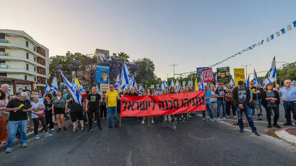 Hayfa, İsrail - 24 Mayıs 2025: Çeşitli tabelaları ve bayrakları olan insanlar, savaşın sona ermesi, rehine anlaşmasının tamamlanması ve yeni seçimlerin başlatılması için düzenlenen protesto mitingine katıldılar. Hayfa, İsrail