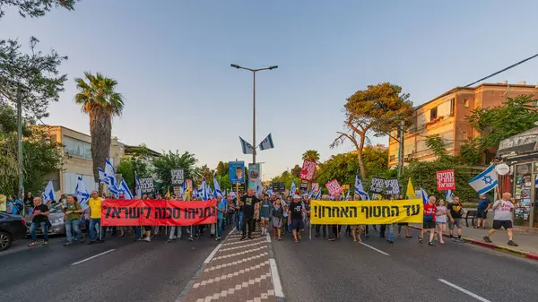 Hayfa, İsrail - 24 Mayıs 2025: Çeşitli tabelaları ve bayrakları olan insanlar, savaşın sona ermesi, rehine anlaşmasının tamamlanması ve yeni seçimlerin başlatılması için düzenlenen protesto mitingine katıldılar. Hayfa, İsrail
