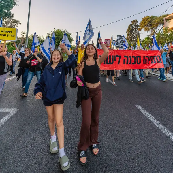 Hayfa, İsrail - 24 Mayıs 2025: Çeşitli tabelaları ve bayrakları olan insanlar, savaşın sona ermesi, rehine anlaşmasının tamamlanması ve yeni seçimlerin başlatılması için düzenlenen protesto mitingine katıldılar. Hayfa, İsrail