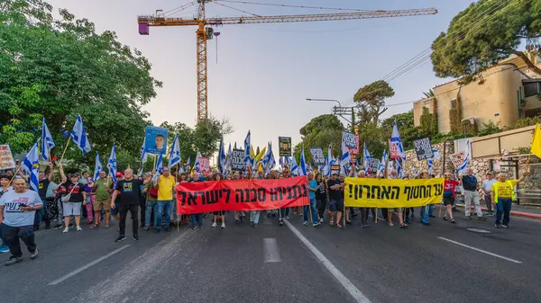 Hayfa, İsrail - 24 Mayıs 2025: Çeşitli tabelaları ve bayrakları olan insanlar, savaşın sona ermesi, rehine anlaşmasının tamamlanması ve yeni seçimlerin başlatılması için düzenlenen protesto mitingine katıldılar. Hayfa, İsrail