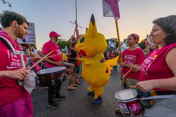 Hayfa, İsrail - 24 Mayıs 2025: Bateri çemberi, Pikachu kostümlü bir adam, savaşın sona ermesi, rehine anlaşmasının tamamlanması ve yeni seçimler için düzenlenen protesto mitinginin bir parçası. Hayfa, İsrail