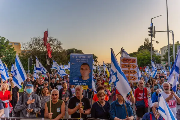 Hayfa, İsrail - 24 Mayıs 2025: Çeşitli tabela ve bayraklara sahip bir grup insan, savaşın sona ermesi, rehine anlaşmasının tamamlanması ve yeni seçimler için düzenlenen protesto mitingine katıldı. Hayfa, İsrail