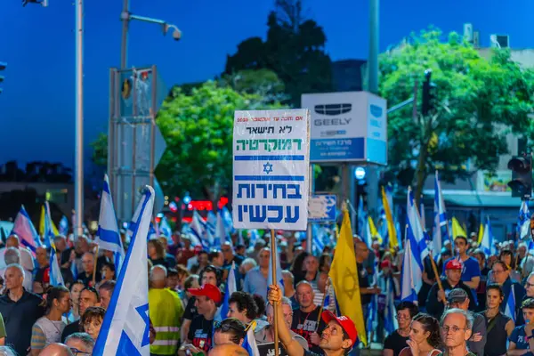 Hayfa, İsrail - 24 Mayıs 2025: Çeşitli tabela ve bayraklara sahip bir grup insan, savaşın sona ermesi, rehine anlaşmasının tamamlanması ve yeni seçimler için düzenlenen protesto mitingine katıldı. Hayfa, İsrail