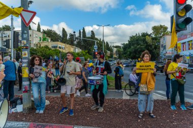 Hayfa, İsrail - 28 Mayıs 2025: İnsanlar, savaşın 600. gününde İsrail 'in Hayfa kentinde, anlaşmanın tamamlanması çağrısında bulunarak, savaşın 600. gününde sarı kurdele, işaret ve bayraklarla protesto ediyorlar.