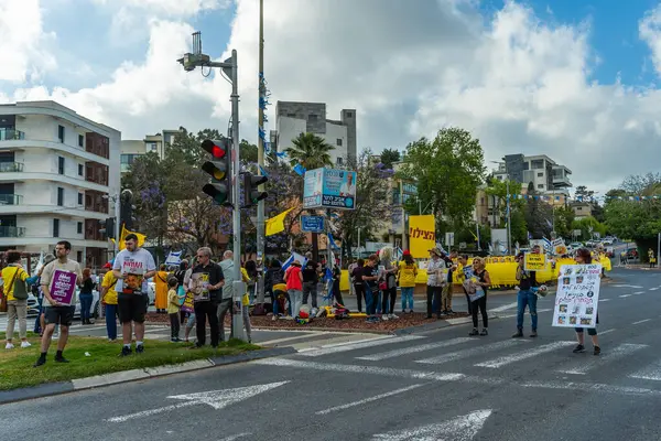 Hayfa, İsrail - 28 Mayıs 2025: İnsanlar, savaşın 600. gününde İsrail 'in Hayfa kentinde, anlaşmanın tamamlanması çağrısında bulunarak, savaşın 600. gününde sarı kurdele, işaret ve bayraklarla protesto ediyorlar.