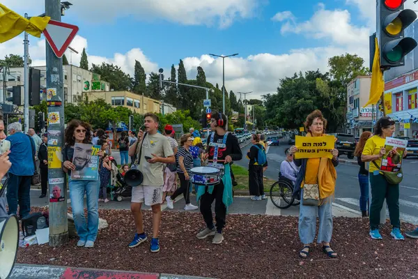 Hayfa, İsrail - 28 Mayıs 2025: İnsanlar, savaşın 600. gününde İsrail 'in Hayfa kentinde, anlaşmanın tamamlanması çağrısında bulunarak, savaşın 600. gününde sarı kurdele, işaret ve bayraklarla protesto ediyorlar.