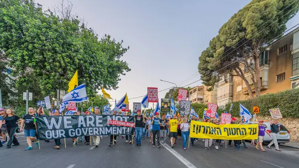 Hayfa, İsrail - 31 Mayıs 2025: Çeşitli tabelaları ve bayrakları olan insanlar, savaşın sona ermesi, rehine anlaşmasının tamamlanması ve yeni seçimlerin başlatılması için düzenlenen protesto mitingine katıldılar. Hayfa, İsrail