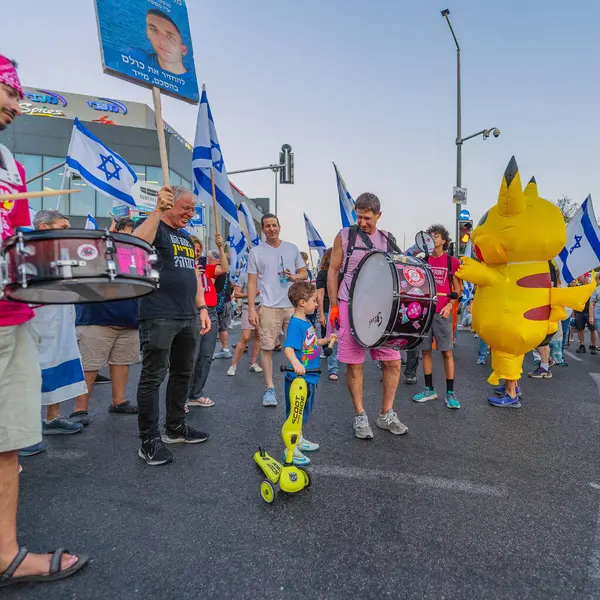 Hayfa, İsrail - 31 Mayıs 2025: Davul çemberi, Pikachu kostümlü bir adamla, savaşın sona ermesi, rehine anlaşmasının tamamlanması ve yeni seçimler için düzenlenen protesto mitinginin bir parçası. Hayfa, İsrail