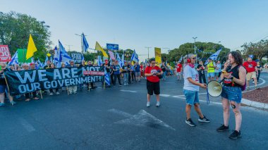 Hayfa, İsrail - 31 Mayıs 2025: Çeşitli tabelaları ve bayrakları olan insanlar, savaşın sona ermesi, rehine anlaşmasının tamamlanması ve yeni seçimlerin başlatılması için düzenlenen protesto mitingine katıldılar. Hayfa, İsrail