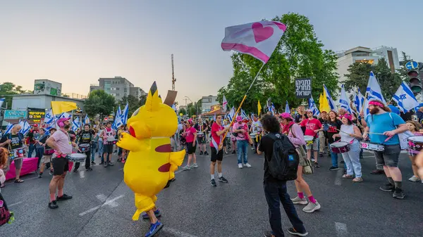 Hayfa, İsrail - 31 Mayıs 2025: Davul çemberi, Pikachu kostümlü bir adamla, savaşın sona ermesi, rehine anlaşmasının tamamlanması ve yeni seçimler için düzenlenen protesto mitinginin bir parçası. Hayfa, İsrail