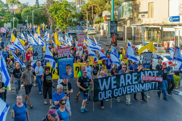 Hayfa, İsrail - 31 Mayıs 2025: Çeşitli tabelaları ve bayrakları olan insanlar, savaşın sona ermesi, rehine anlaşmasının tamamlanması ve yeni seçimlerin başlatılması için düzenlenen protesto mitingine katıldılar. Hayfa, İsrail