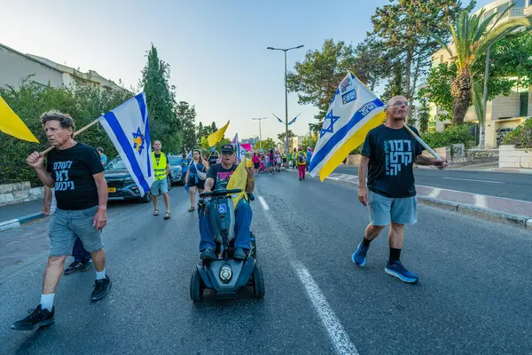 Hayfa, İsrail - 31 Mayıs 2025: Çeşitli tabelaları ve bayrakları olan insanlar, savaşın sona ermesi, rehine anlaşmasının tamamlanması ve yeni seçimlerin başlatılması için düzenlenen protesto mitingine katıldılar. Hayfa, İsrail