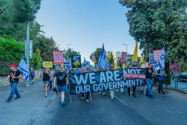 Hayfa, İsrail - 31 Mayıs 2025: Çeşitli tabelaları ve bayrakları olan insanlar, savaşın sona ermesi, rehine anlaşmasının tamamlanması ve yeni seçimlerin başlatılması için düzenlenen protesto mitingine katıldılar. Hayfa, İsrail