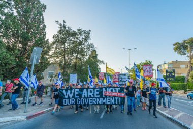 Hayfa, İsrail - 31 Mayıs 2025: Çeşitli tabelaları ve bayrakları olan insanlar, savaşın sona ermesi, rehine anlaşmasının tamamlanması ve yeni seçimlerin başlatılması için düzenlenen protesto mitingine katıldılar. Hayfa, İsrail