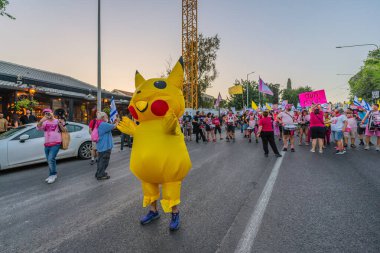Hayfa, İsrail - 31 Mayıs 2025: İnsanlar (Pikachu kostümlü adamla birlikte) savaşın sona ermesi, rehine anlaşmasının tamamlanması ve yeni seçimler çağrısında bulunan bir protesto yürüyüşüne katılıyor. Hayfa, İsrail