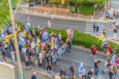Hayfa, İsrail - 31 Mayıs 2025: Çeşitli tabelaları ve bayrakları olan insanlar, savaşın sona ermesi, rehine anlaşmasının tamamlanması ve yeni seçimlerin başlatılması için düzenlenen protesto mitingine katıldılar. Hayfa, İsrail