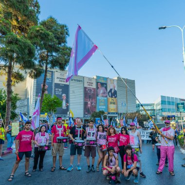 Hayfa, İsrail - Haziran 07, 2025: İnsanlar savaşın sona ermesi, rehine anlaşmasının tamamlanması ve yeni seçimler çağrısında bulunan bir protesto yürüyüşüne (Pembe Cephe Grubu) katılıyor. Hayfa, İsrail