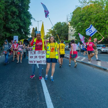 Hayfa, İsrail - 7 Haziran 2025: Çeşitli tabela ve bayraklara sahip insanlar, savaşın sona ermesi, rehine anlaşmasının tamamlanması ve yeni seçimlerin başlatılması için düzenlenen protesto mitingine katıldılar. Hayfa, İsrail