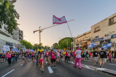 Hayfa, İsrail - Haziran 07, 2025: İnsanlar savaşın sona ermesi, rehine anlaşmasının tamamlanması ve yeni seçimler çağrısında bulunan bir protesto yürüyüşüne (Pembe Cephe Grubu) katılıyor. Hayfa, İsrail