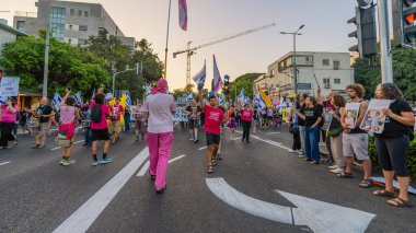 Hayfa, İsrail - Haziran 07, 2025: İnsanlar savaşın sona ermesi, rehine anlaşmasının tamamlanması ve yeni seçimler çağrısında bulunan bir protesto yürüyüşüne (Pembe Cephe Grubu) katılıyor. Hayfa, İsrail