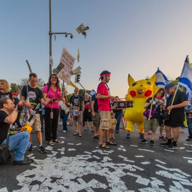 Hayfa, İsrail - Haziran 07, 2025: Davul çemberi, sembolik Katar parasıyla ve Hayfa, İsrail 'deki bir protesto mitinginin bir parçası olan Pikachu kostümlü adamla