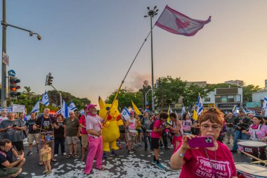 Hayfa, İsrail - Haziran 07, 2025: Davul çemberi, sembolik Katar parasıyla ve Hayfa, İsrail 'deki bir protesto mitinginin bir parçası olan Pikachu kostümlü adamla