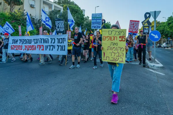 Hayfa, İsrail - 7 Haziran 2025: Çeşitli tabela ve bayraklara sahip insanlar, savaşın sona ermesi, rehine anlaşmasının tamamlanması ve yeni seçimlerin başlatılması için düzenlenen protesto mitingine katıldılar. Hayfa, İsrail