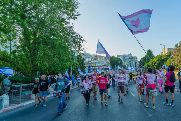 Hayfa, İsrail - Haziran 07, 2025: İnsanlar savaşın sona ermesi, rehine anlaşmasının tamamlanması ve yeni seçimler çağrısında bulunan bir protesto yürüyüşüne (Pembe Cephe Grubu) katılıyor. Hayfa, İsrail