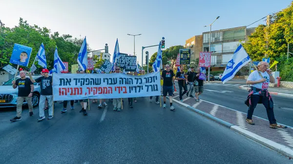 Hayfa, İsrail - 7 Haziran 2025: Çeşitli tabela ve bayraklara sahip insanlar, savaşın sona ermesi, rehine anlaşmasının tamamlanması ve yeni seçimlerin başlatılması için düzenlenen protesto mitingine katıldılar. Hayfa, İsrail
