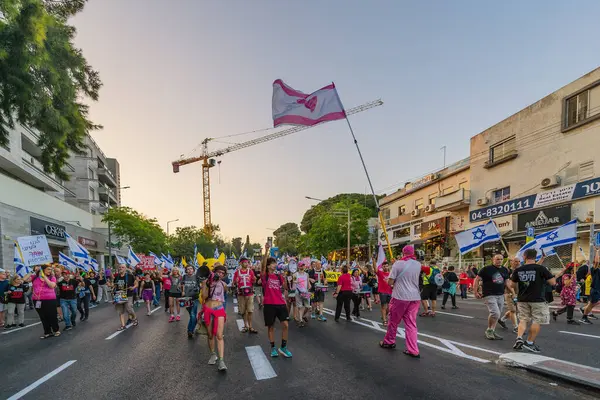 Hayfa, İsrail - Haziran 07, 2025: İnsanlar savaşın sona ermesi, rehine anlaşmasının tamamlanması ve yeni seçimler çağrısında bulunan bir protesto yürüyüşüne (Pembe Cephe Grubu) katılıyor. Hayfa, İsrail